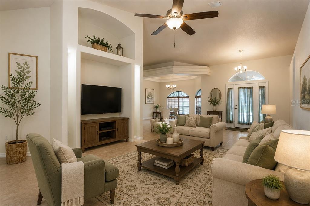 A living room features a vaulted ceiling, a television niche, and neutral-toned furniture — 3 ZODIAC PLACE, PALM COAST, FL