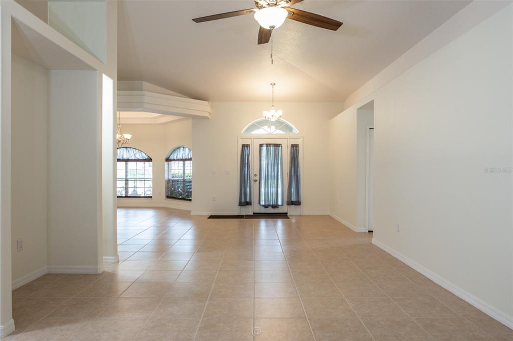 An interior view of a tiled foyer featuring a front door with sidelights and transom — 3 ZODIAC PLACE, PALM COAST, FL