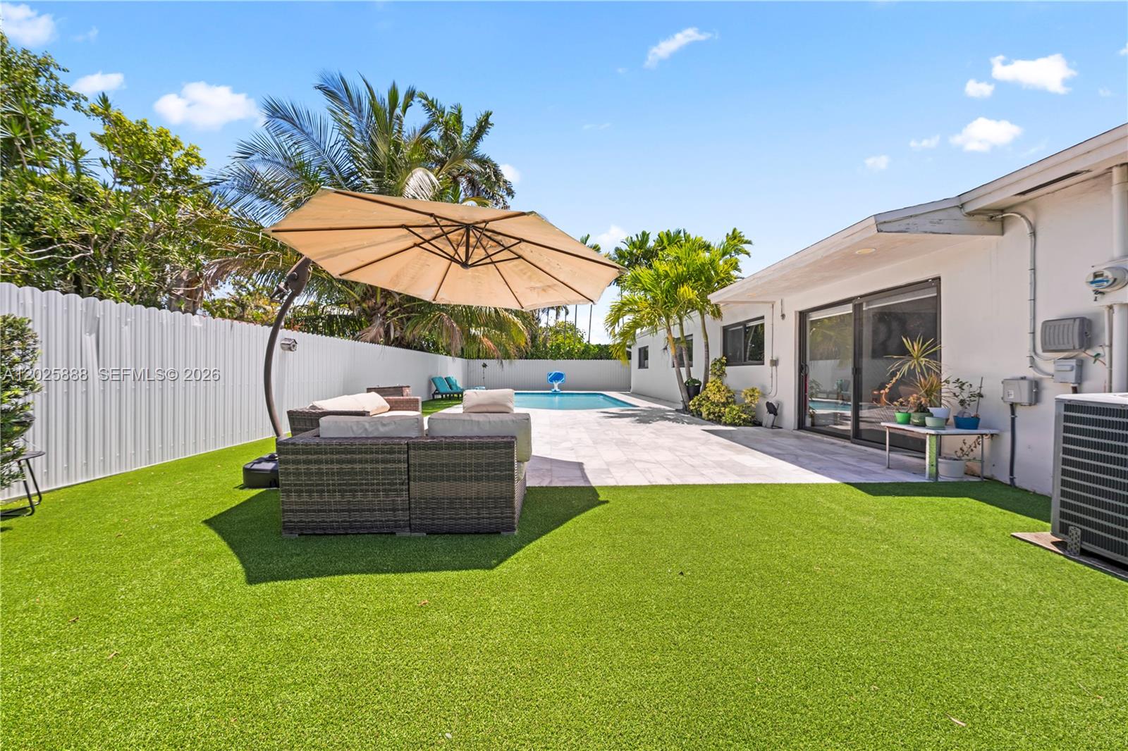 A backyard features artificial turf, a patio with outdoor furniture, a pool, and palm trees — 12731 SW 47th Ter, Miami FL 33175, MIAMI, FL