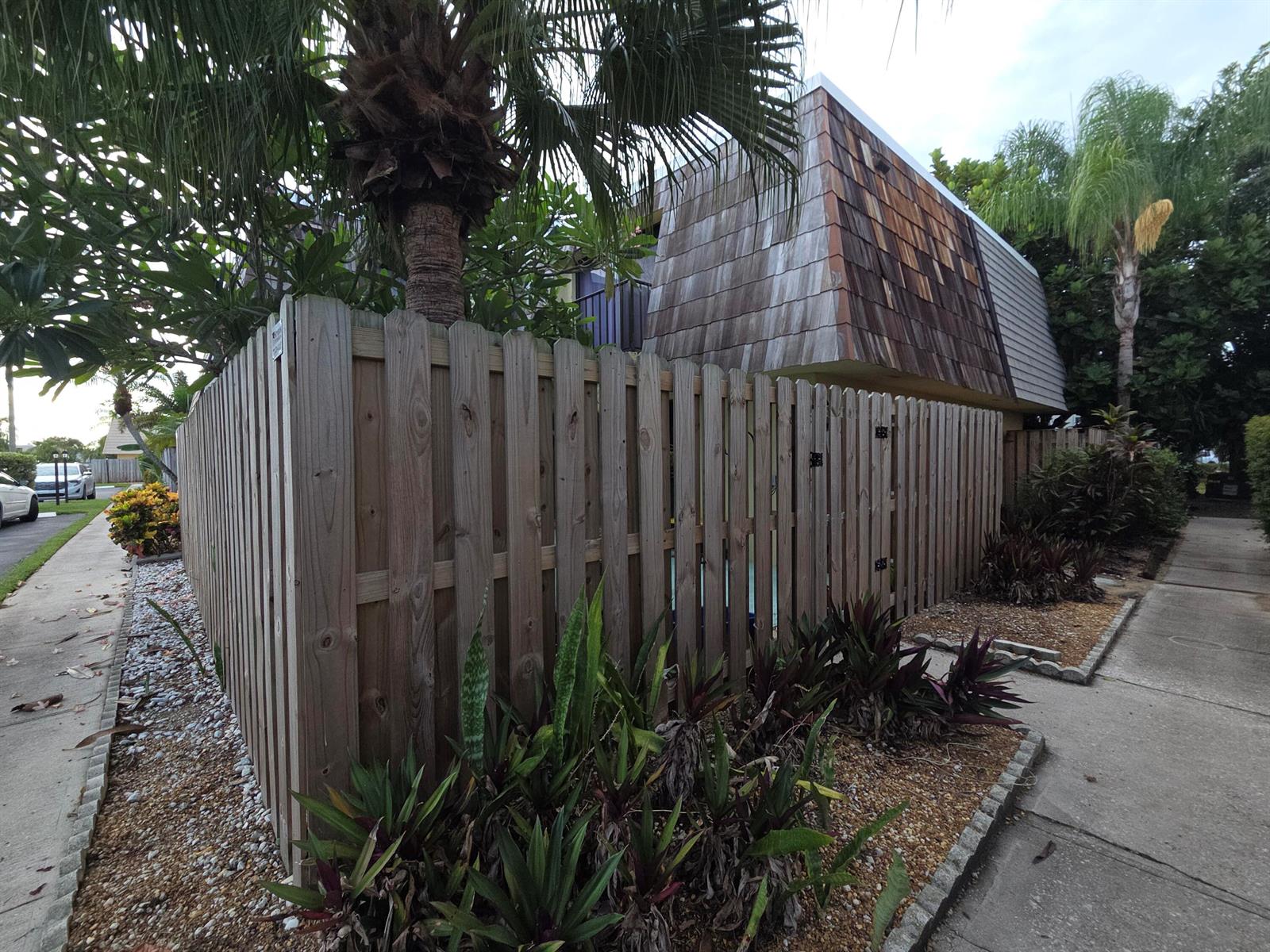 A wooden privacy fence surrounds a patio area next to a building with shingled siding — 1170 6th Avenue # 3a, Vero Beach FL 32960, VERO BEACH, FL