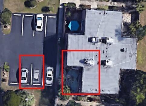 This aerial view shows a building rooftop and an adjacent parking lot with several cars — 1170 6th Avenue # 3a, Vero Beach FL 32960, VERO BEACH, FL