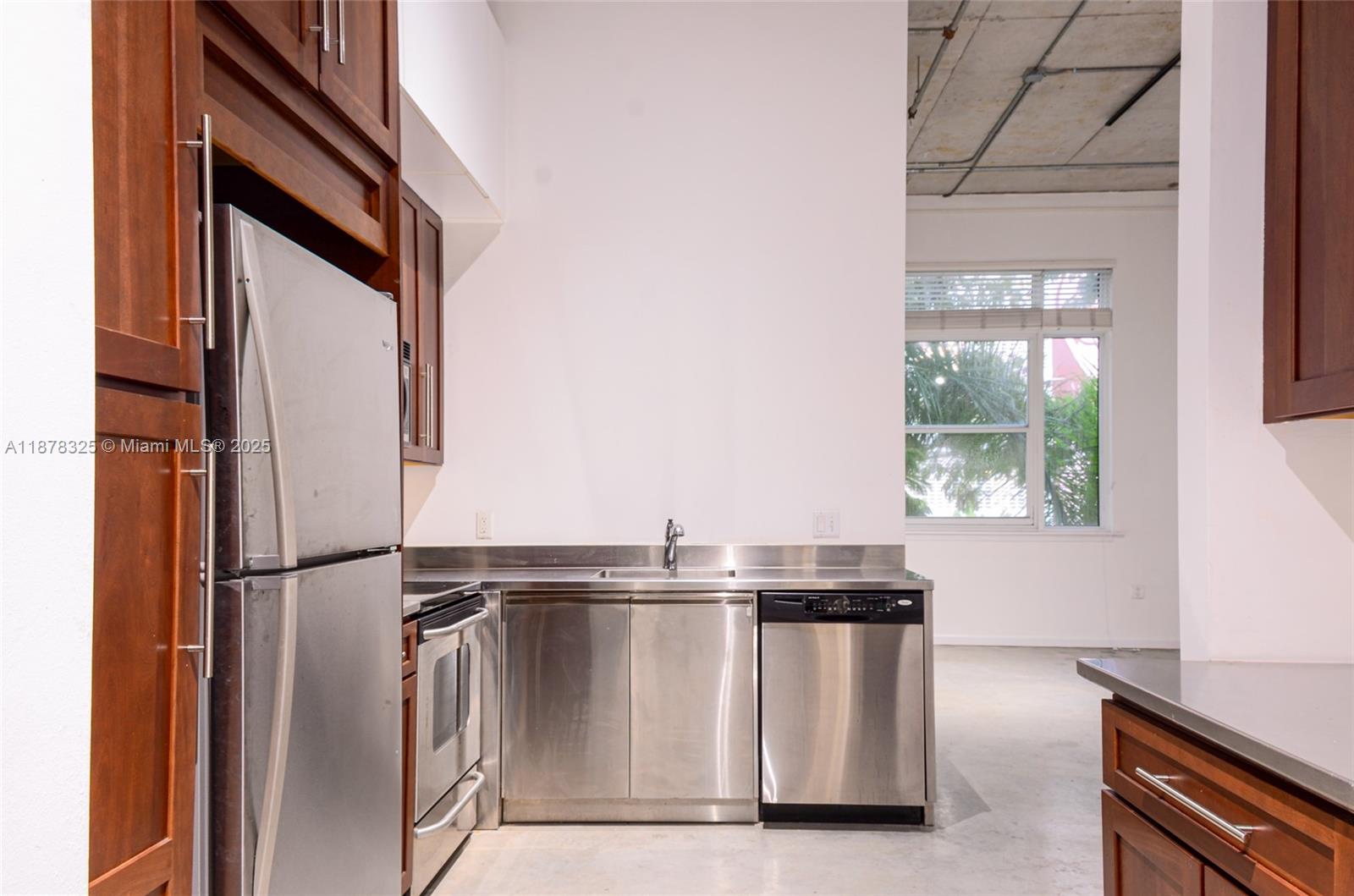 A kitchen features stainless steel appliances, metal countertops, and dark wood cabinetry — 250 NW 23rd st # 308, Miami FL 33127, MIAMI, FL