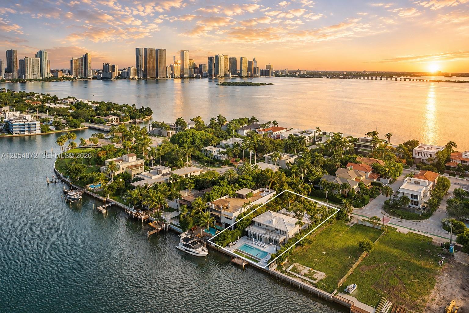 An aerial view shows a waterfront house with a pool and boat dock at sunset — 1300 S Venetian Way, Miami FL 33139, MIAMI, FL
