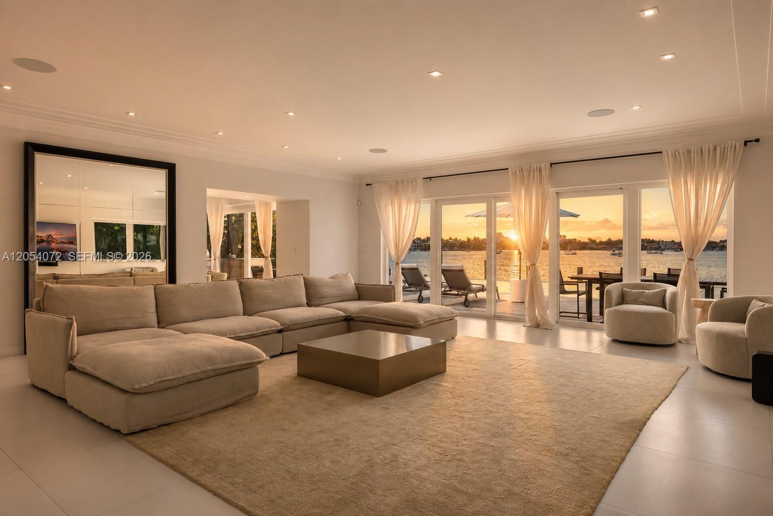 A spacious living room features a large sectional sofa, a coffee table, and waterfront views — 1300 S Venetian Way, Miami FL 33139, MIAMI, FL