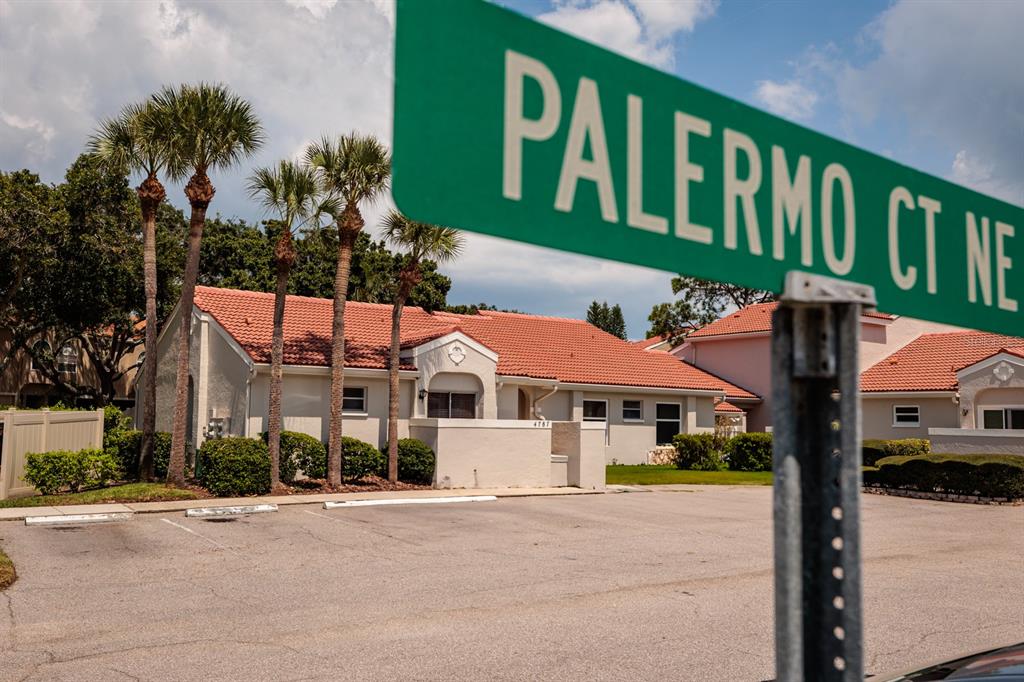 A street sign for Palermo Ct NE stands in front of a one-story residential building — 4787 PALERMO COURT NE UNIT 4787, ST PETERSBURG, FL