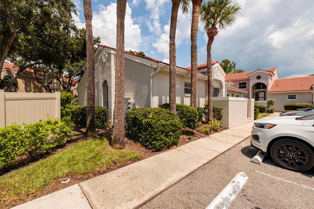 A beige stucco building with a red tile roof stands beside a sidewalk and parking — 4787 PALERMO COURT NE UNIT 4787, ST PETERSBURG, FL