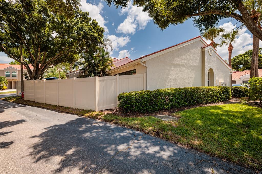 A beige stucco house with a white vinyl fence and a paved driveway — 4787 PALERMO COURT NE UNIT 4787, ST PETERSBURG, FL