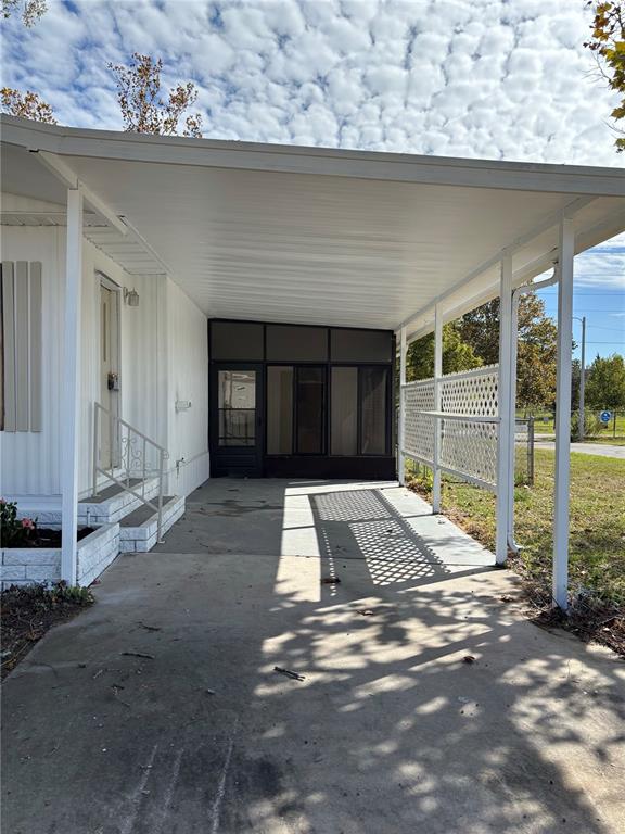 A white mobile home with a carport and a large tree in the front yard — 9863 SCEPTER AVENUE, BROOKSVILLE, FL