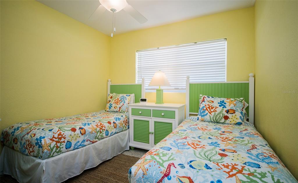 A bedroom features two twin beds with colorful sea-life bedding and a central nightstand — 1312 66TH STREET NW, BRADENTON, FL