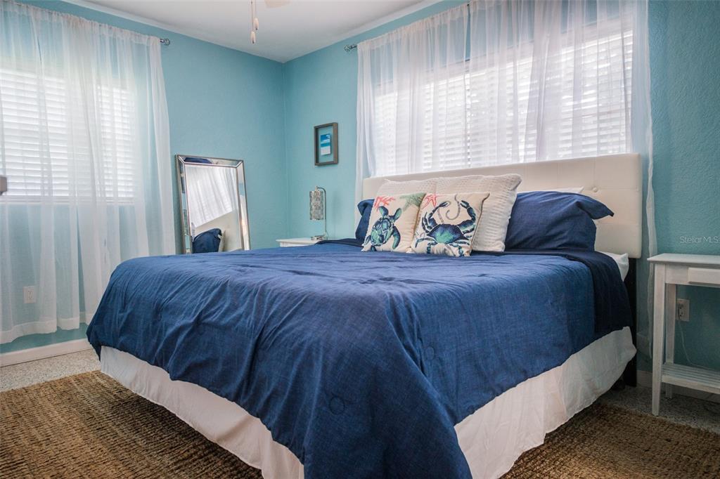 A bedroom features light blue walls, a white headboard, and a blue bedspread — 1312 66TH STREET NW, BRADENTON, FL