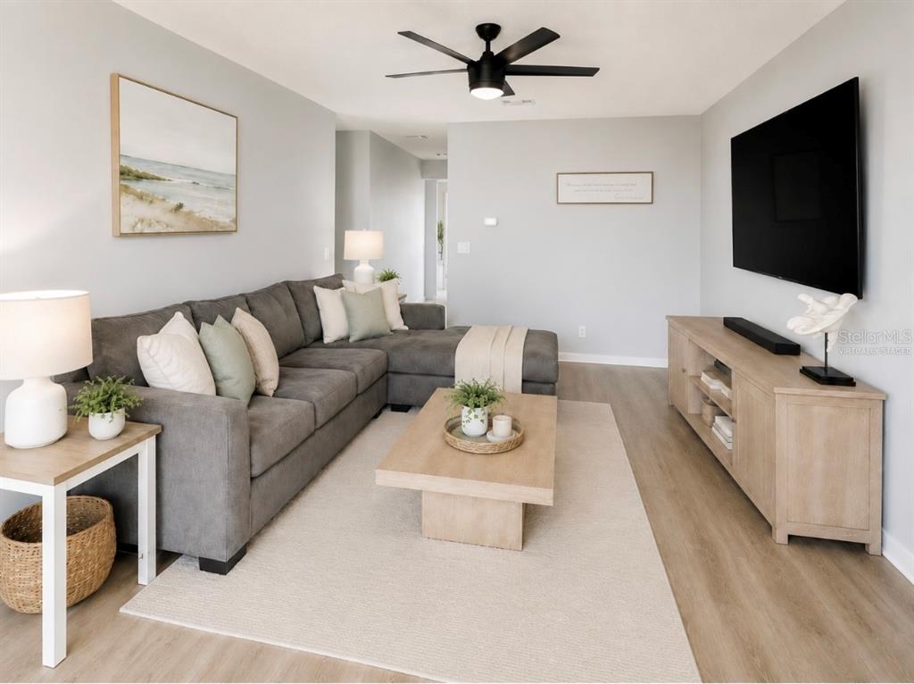 A living room features a gray sectional sofa, a wooden coffee table, and a television — 6 MASTERS COURT UNIT 6, PALM COAST, FL