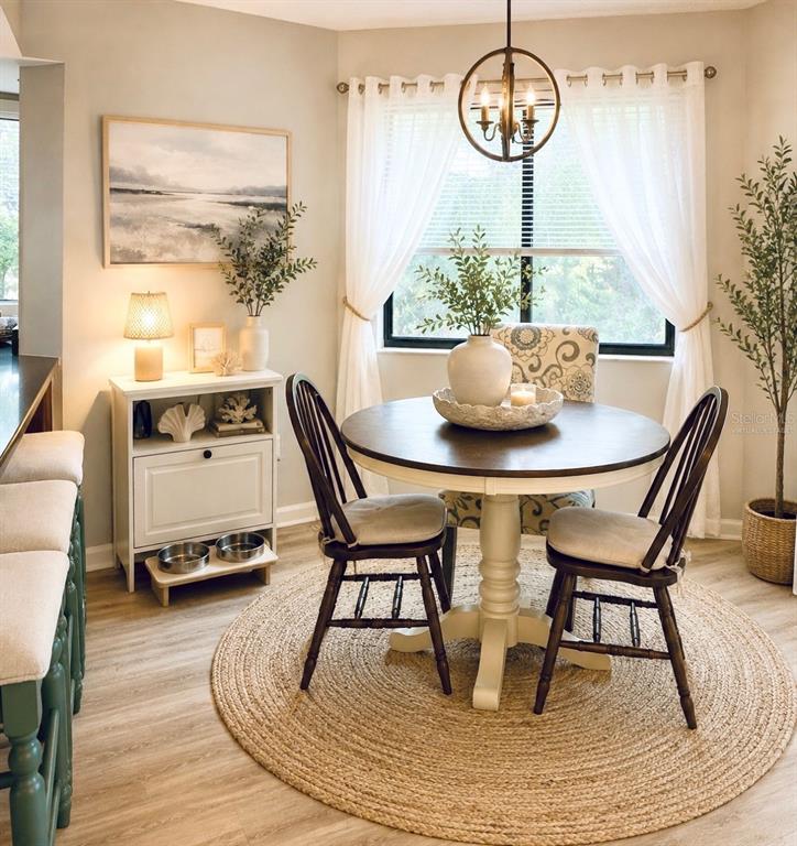 A dining area features a round table, two wooden chairs, and a white storage cabinet — 6 MASTERS COURT UNIT 6, PALM COAST, FL