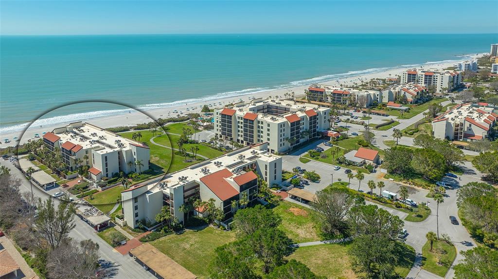 An aerial view shows a multi-story beachside condominium complex with a circled building — 1925 GULF OF MEXICO DRIVE UNIT G8-302, LONGBOAT KEY, FL