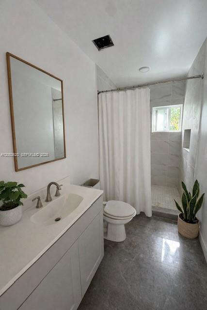 A bathroom featuring a vanity with a sink, a toilet, and a tiled walk-in shower — 6875 NW 4th Ave # A, Miami FL 33150, MIAMI, FL