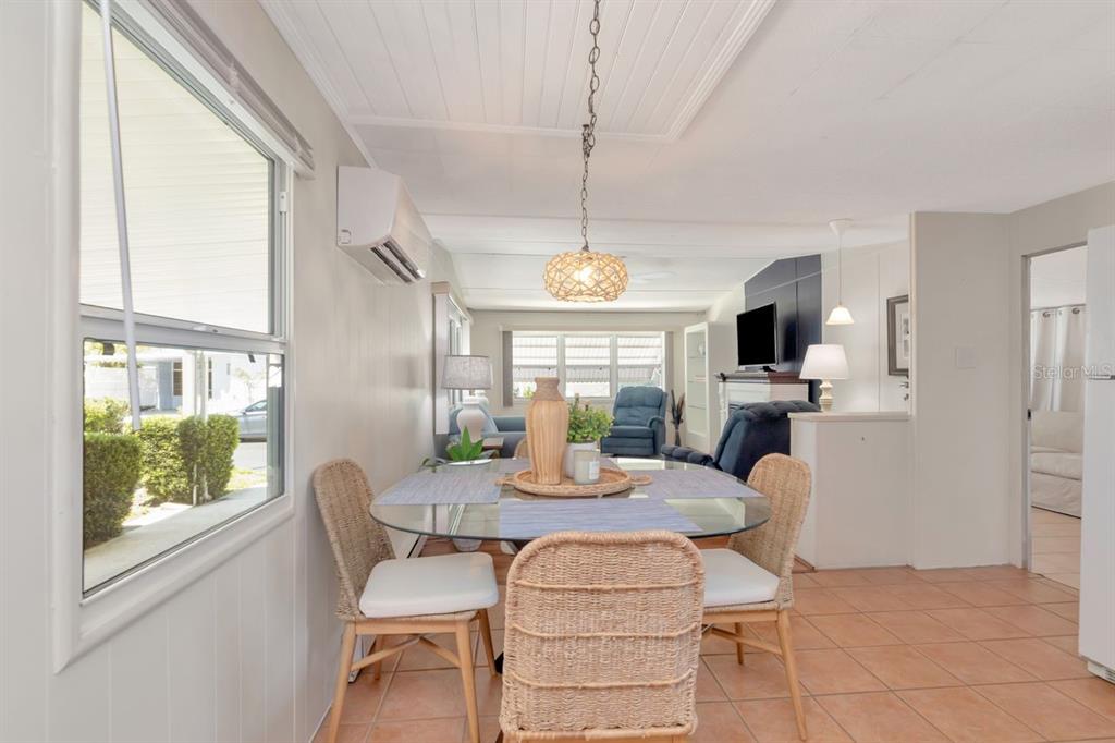 A dining area features a glass-topped table, wicker chairs, and a pendant light fixture — 9900 ULMERTON ROAD UNIT 35, LARGO, FL