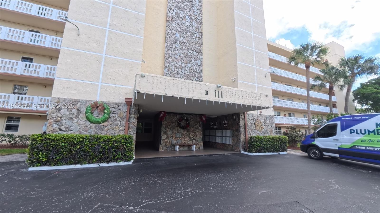 The exterior of a multi-story apartment building features a stone-accented entrance with a covered driveway — 111 SE 3rd Ave # 502, Dania Beach FL 33004, DANIA BEACH, FL