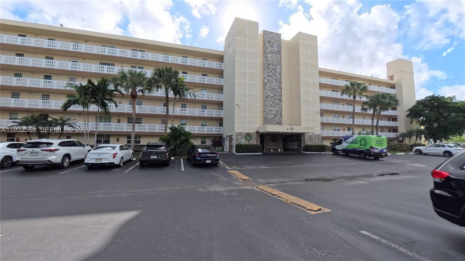 A multi-story apartment building with a stone-accented entrance and a parking lot in front — 111 SE 3rd Ave # 502, Dania Beach FL 33004, DANIA BEACH, FL