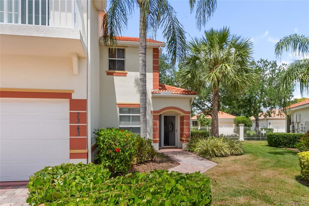 A two-story stucco house with a tile roof, garage, and front entryway with landscaping — 7343 FOUNTAIN PALM CIRCLE UNIT na, BRADENTON, FL