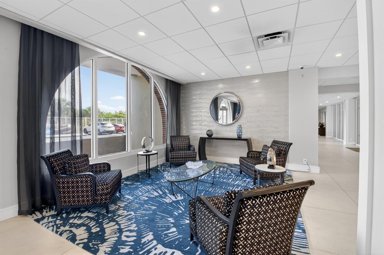 A seating area features four patterned armchairs, a glass coffee table, and a blue rug — 1180 S Ocean Boulevard # 5c, Boca Raton FL 33432, BOCA RATON, FL