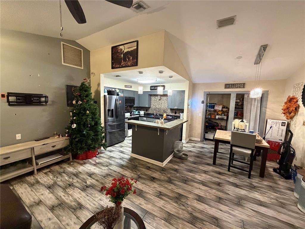 An open-concept living and dining area features wood-look flooring, a kitchen island, and a Christmas tree — 9478 W MARQUETTE LANE, CRYSTAL RIVER, FL