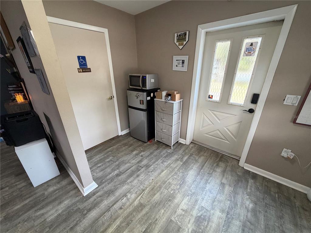 A room features wood-look flooring, a white door, a small refrigerator, and a microwave — 9478 W MARQUETTE LANE, CRYSTAL RIVER, FL