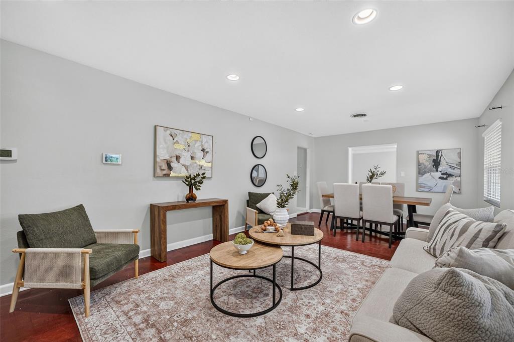 A living and dining area with hardwood floors, neutral walls, and modern furniture — 1448 CUMBIE STREET, ORLANDO, FL