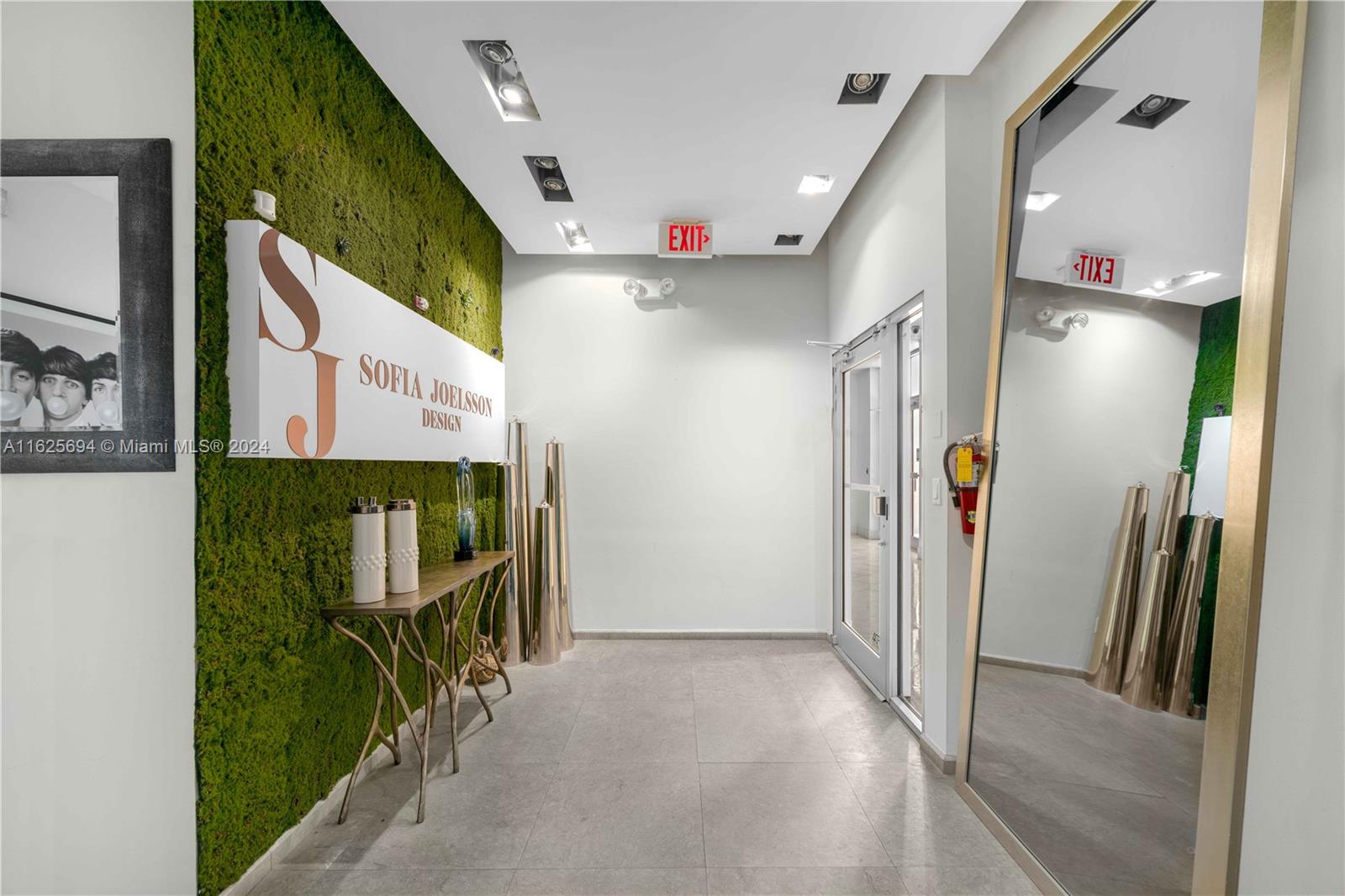 A modern office entryway features a moss wall, a large mirror, and tiled flooring — 1451 Ocean Dr # 204, Miami Beach FL 33139, MIAMI BEACH, FL