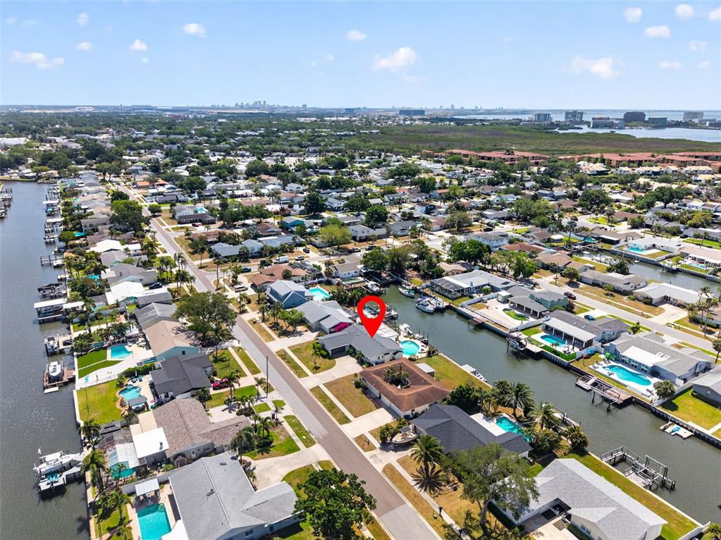 An aerial view shows a waterfront residential neighborhood with a red pin marking a house — 8450 FLAGSTONE DRIVE, TAMPA, FL