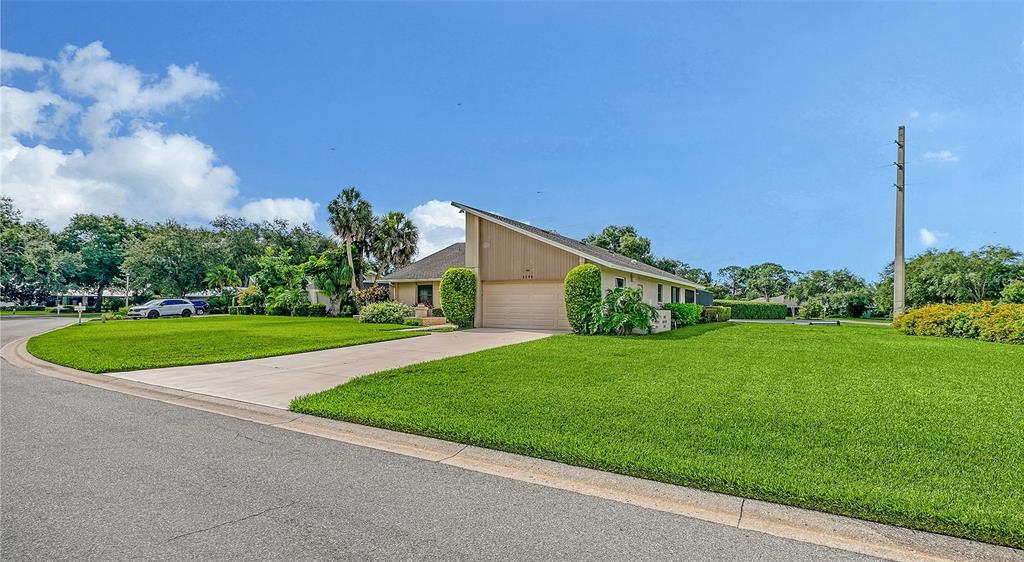 A single-story house with a slanted roof and a concrete driveway sits on a lawn — 3799 COUNTRYSIDE ROAD, SARASOTA, FL