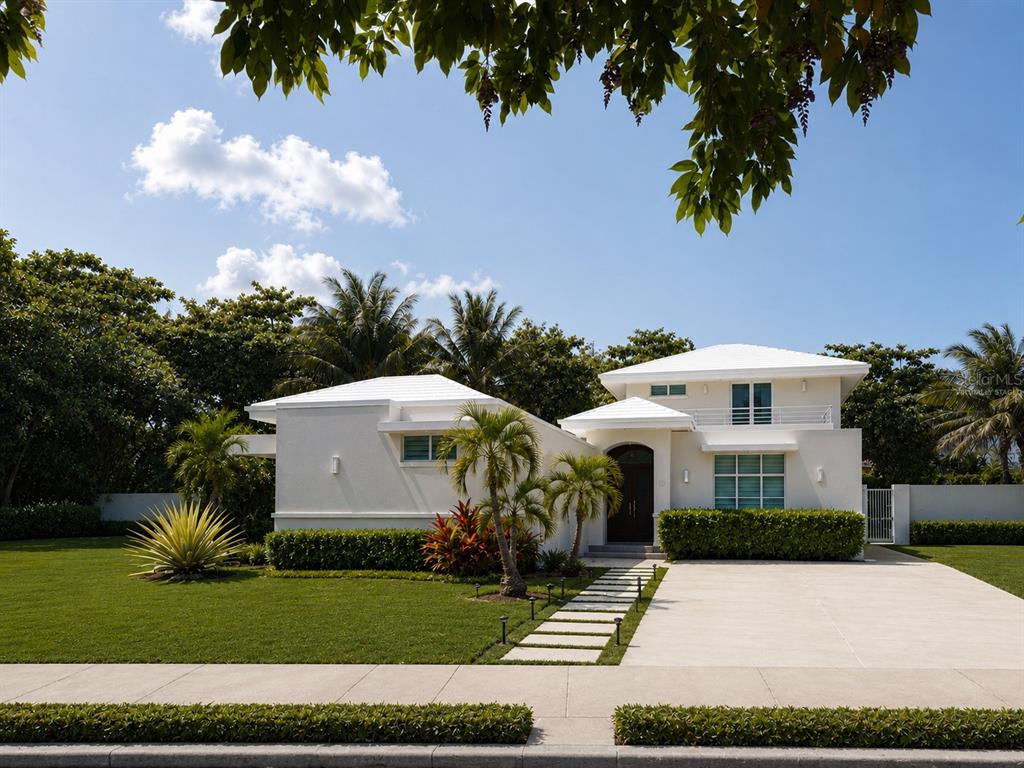 A modern white house with a flat roof, palm trees, and a concrete driveway — OCEAN FOREST Lot 2, RIO GRANDE, PR