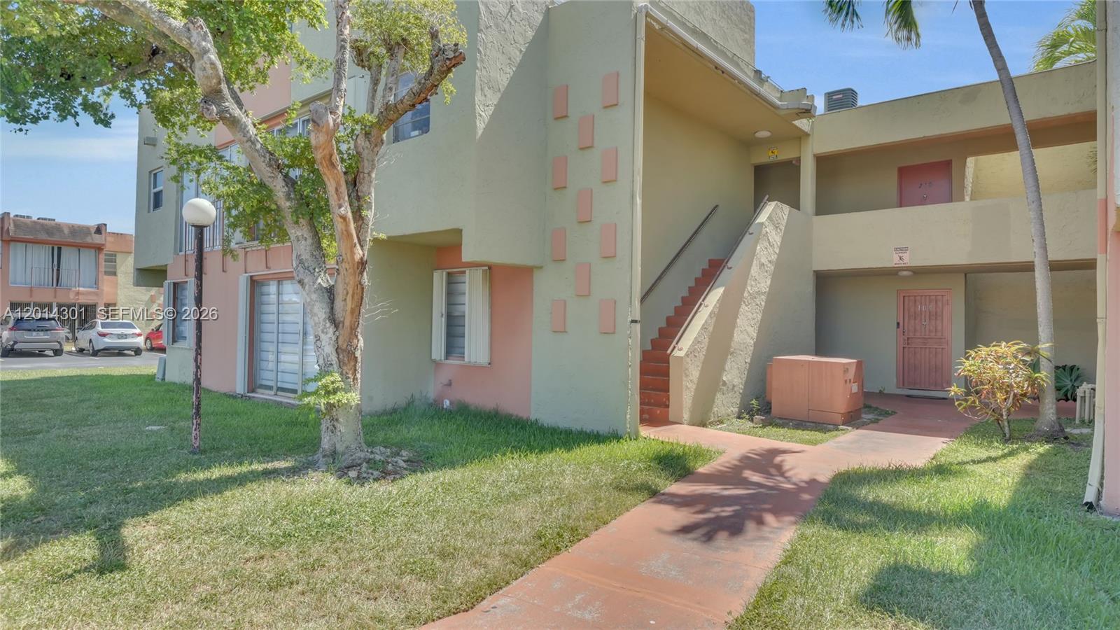 An exterior view of a two-story apartment building with a staircase and a walkway — 9390 W Flagler St # 210A, Miami FL 33174, MIAMI, FL