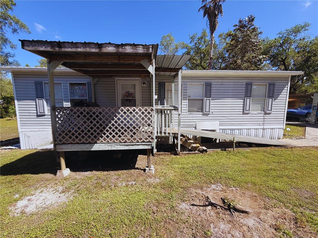 A single-story manufactured home features a front porch with lattice skirting and a wheelchair ramp — 11440 CR 675W, WEBSTER, FL