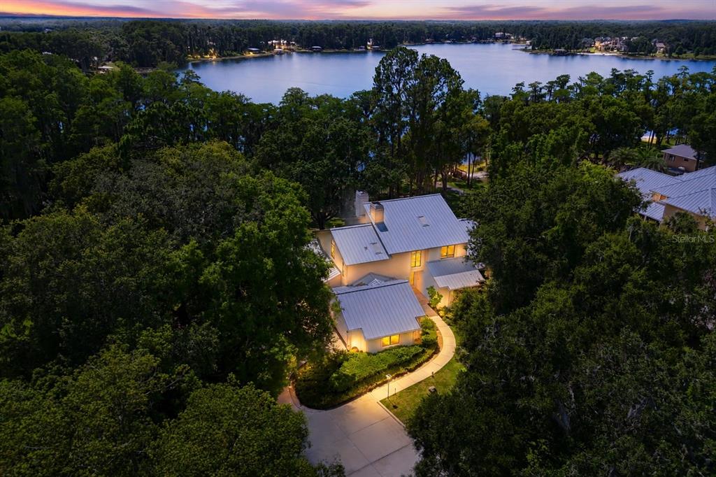 An aerial view of a white house with a metal roof surrounded by dense trees — 17810 CRAWLEY ROAD, ODESSA, FL
