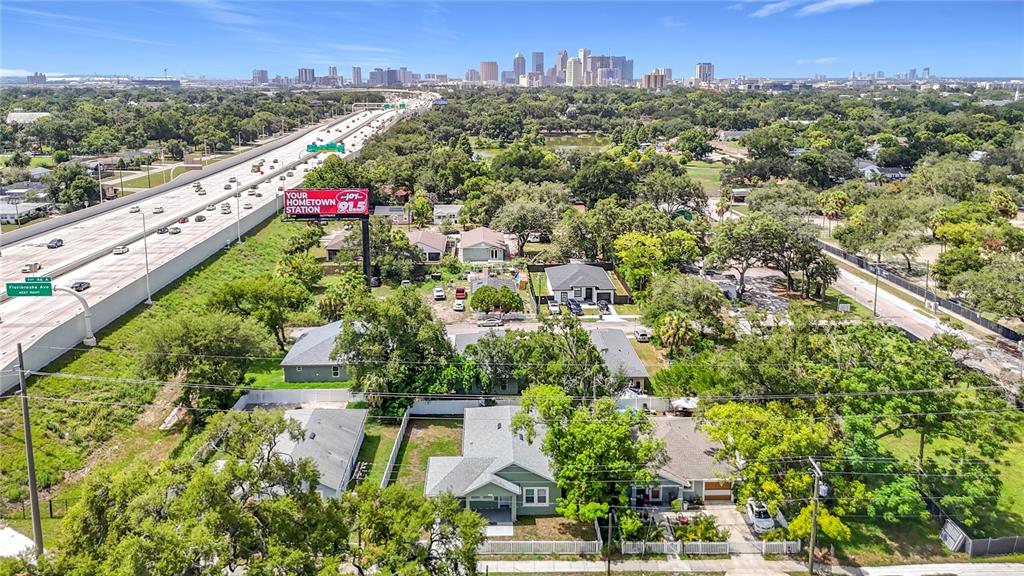 An aerial view shows several houses near a highway with a city skyline in the distance — 509 E LAKE AVENUE, TAMPA, FL