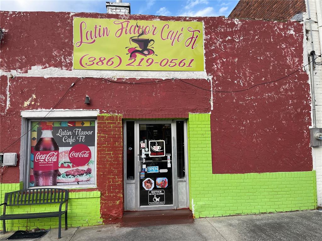 The exterior of a commercial building features a red and lime green brick facade — 111 W HOWARD STREET, LIVE OAK, FL