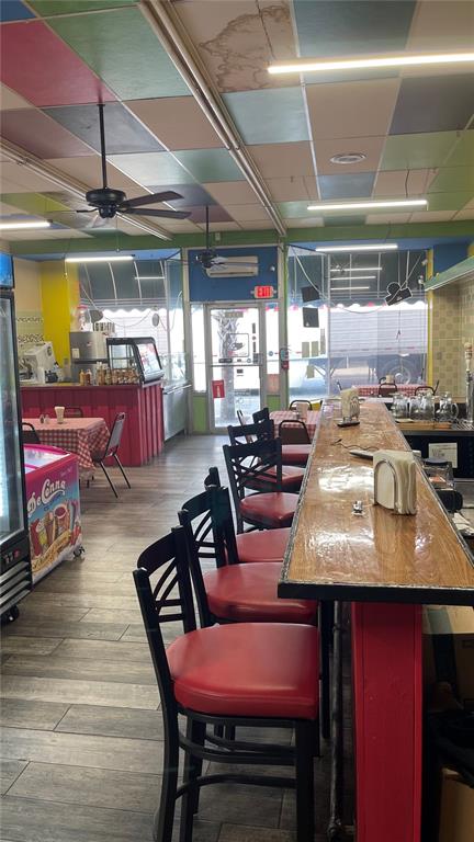 A restaurant interior features a long wooden bar, red chairs, and a colorful tiled ceiling — 111 W HOWARD STREET, LIVE OAK, FL