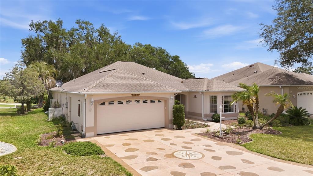 A screened-in patio features a stone-patterned floor, wicker furniture, and views of a golf course — 1344 AUGUSTINE DRIVE, THE VILLAGES, FL