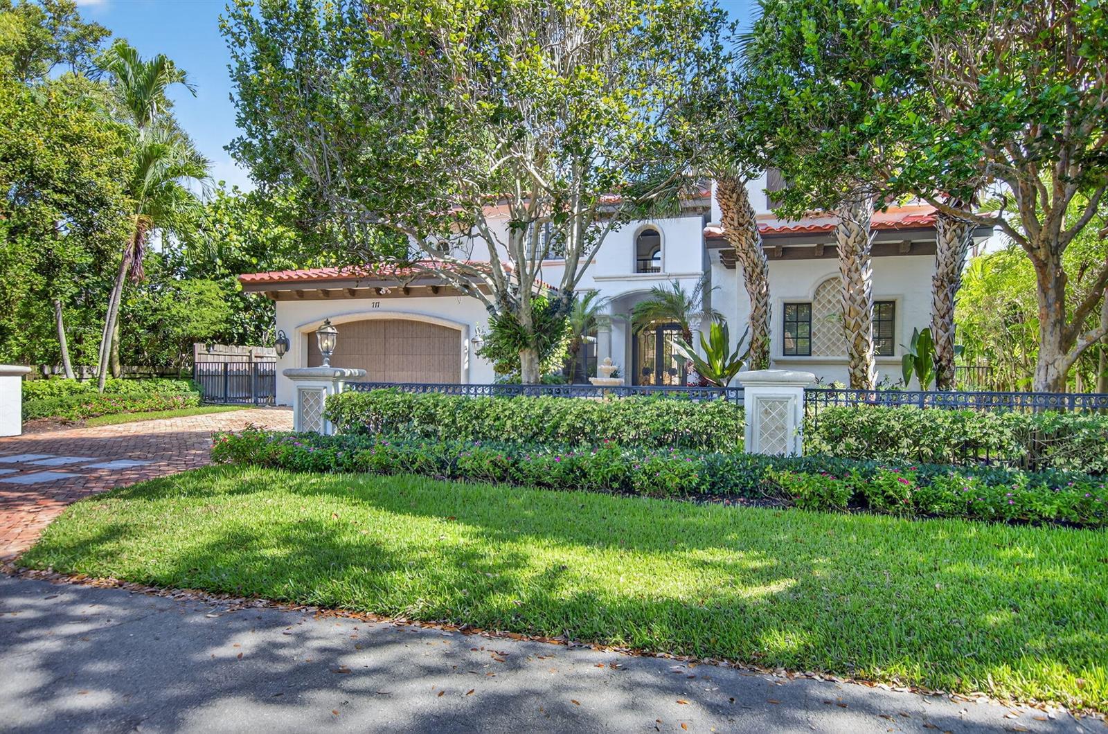 A two-story stucco house with a tile roof, arched garage, and lush landscaping — 717 NW 4th Street, Boca Raton FL 33486, BOCA RATON, FL