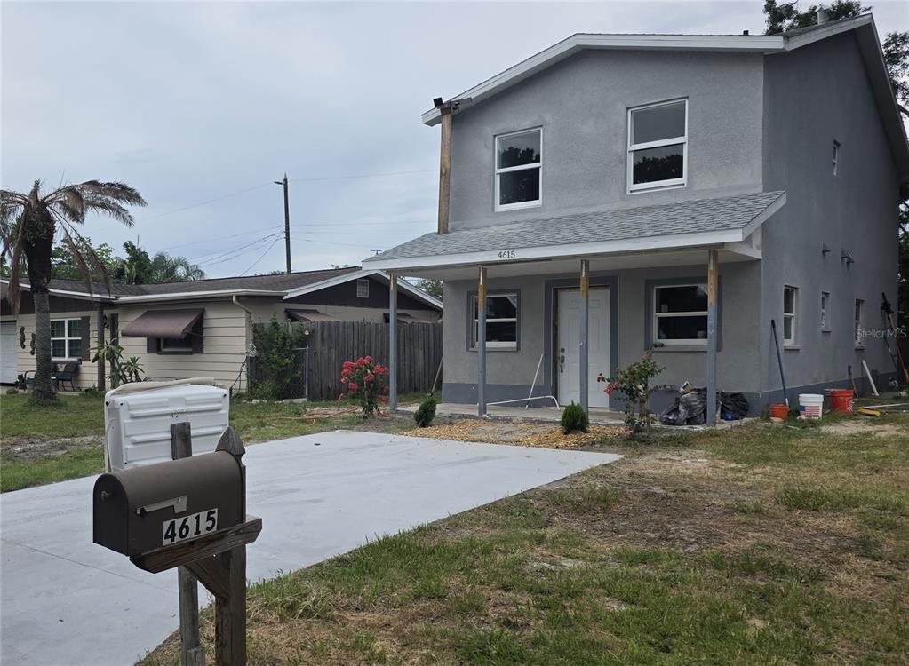 A two-story gray house with a front porch and a concrete driveway — 4615 AEGEAN AVENUE, HOLIDAY, FL