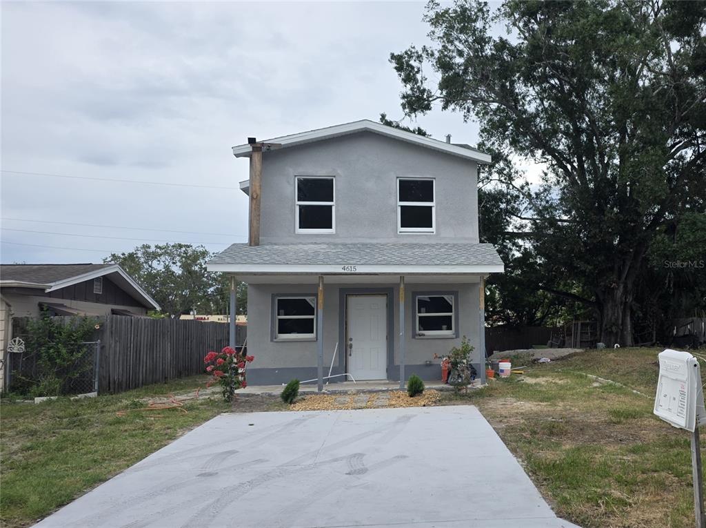 A two-story gray house with a front porch and a concrete driveway — 4615 AEGEAN AVENUE, HOLIDAY, FL
