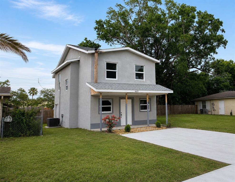 A two-story gray house with a front porch and a concrete driveway — 4615 AEGEAN AVENUE, HOLIDAY, FL