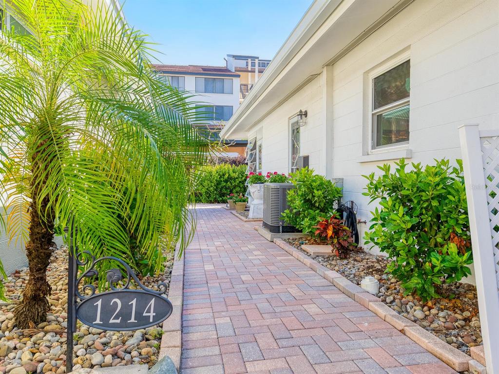A brick walkway leads past a palm tree and a white building with a house number — 1214 MOONMIST CIRCLE UNIT S-01S, SARASOTA, FL