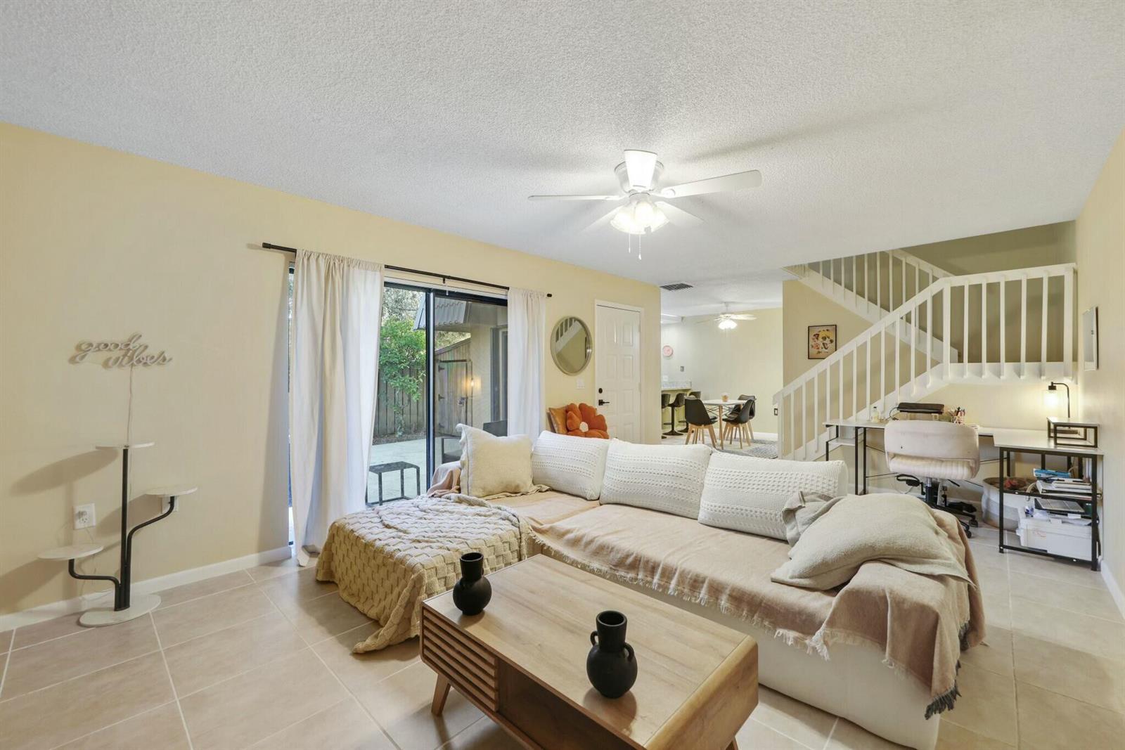 A living room features tile flooring, a sectional sofa, a coffee table, and a staircase — 5110 51st Way, West Palm Beach FL 33409, WEST PALM BEACH, FL