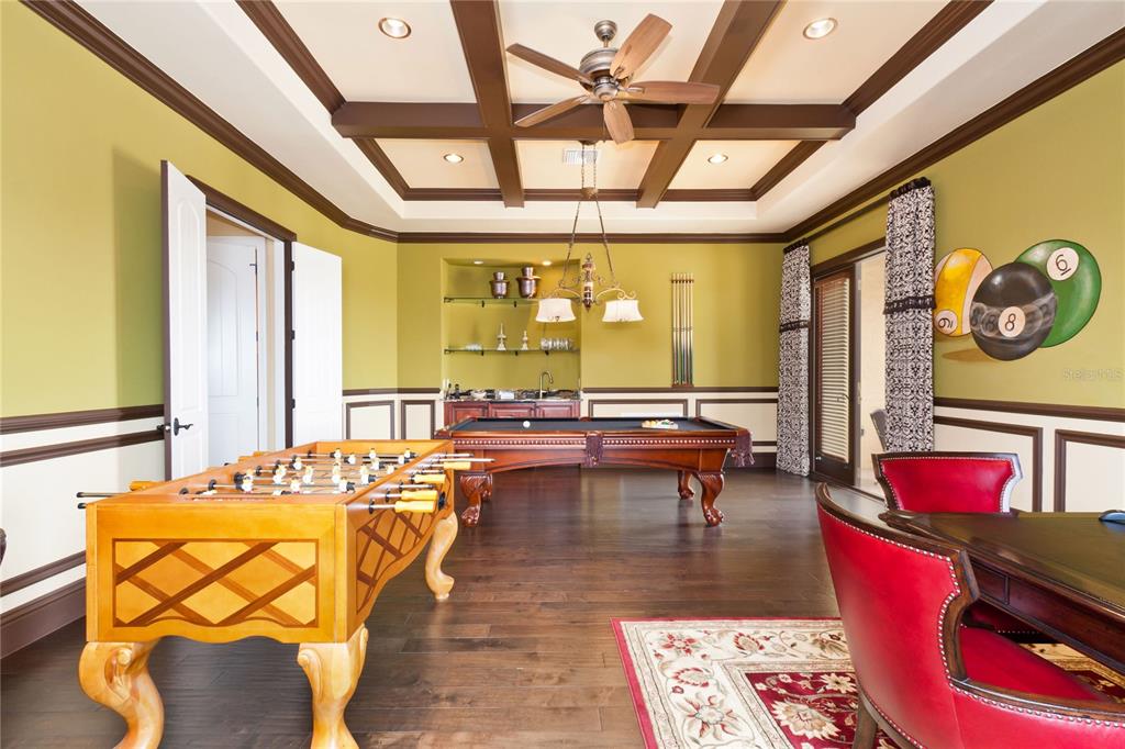 A game room features a foosball table, a pool table, and a coffered ceiling — 7825 PALMILLA COURT, REUNION, FL