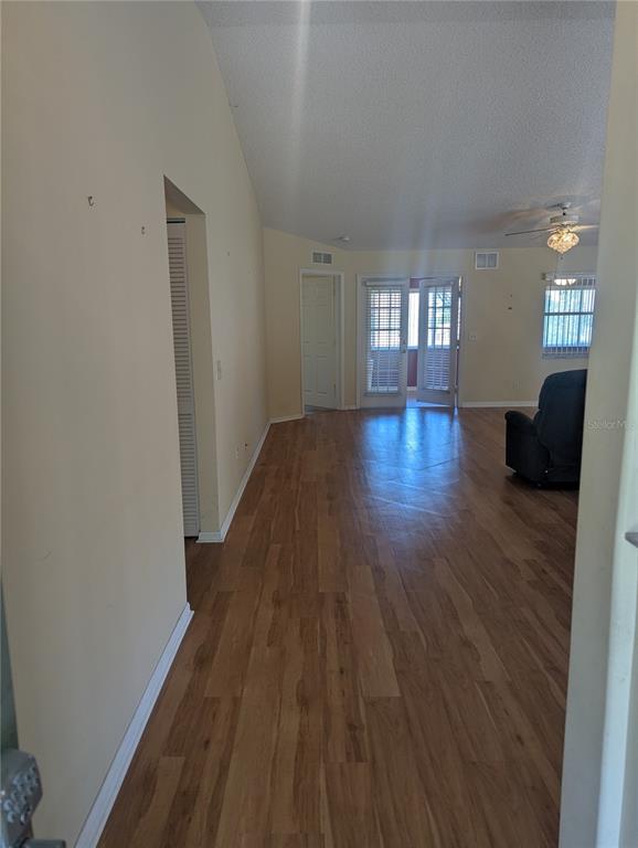 An interior view shows a living area with wood-look flooring, white walls, and glass doors — 9088 SW 91ST TERRACE, OCALA, FL