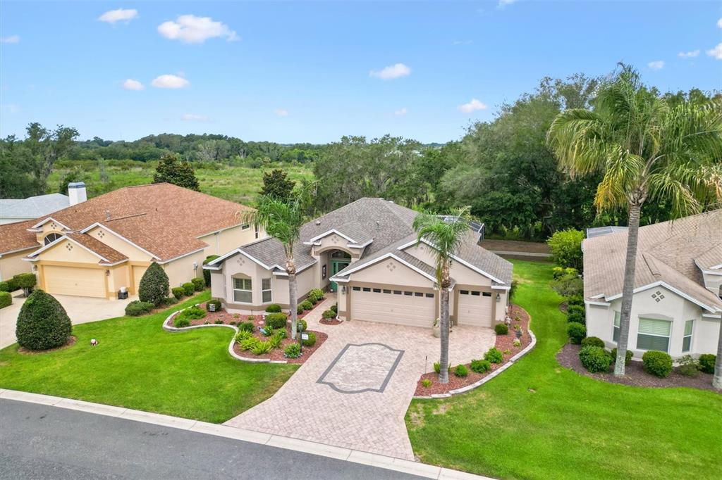 A sunroom features wicker furniture, light wood-look flooring, and large sliding glass doors to a patio — 1816 BLYTHEWOOD LOOP, THE VILLAGES, FL