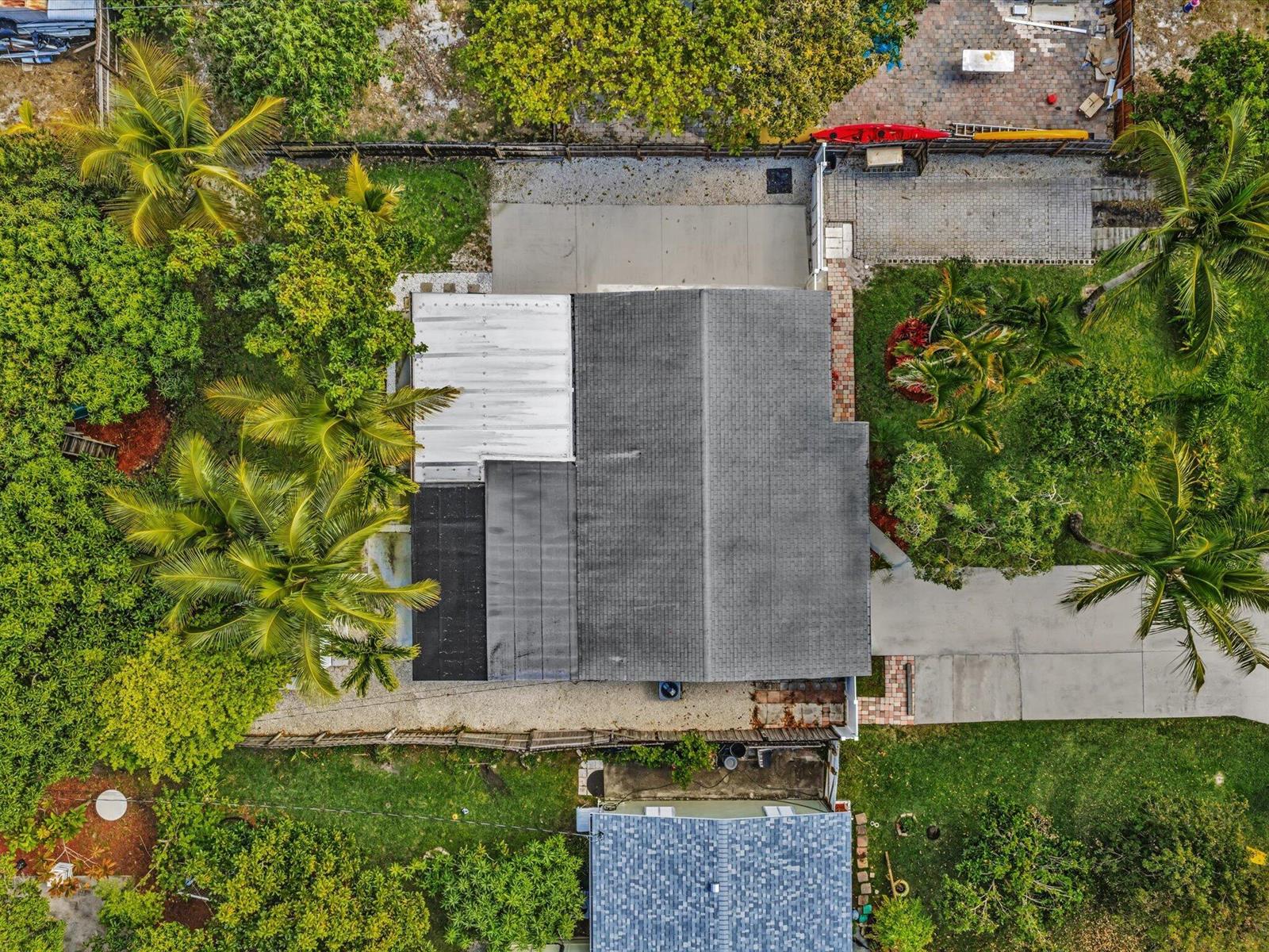 An aerial view shows a house with a gray shingled roof and surrounding tropical landscaping — 607 W Perry Street, Lantana FL 33462, LANTANA, FL