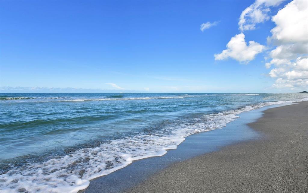 A view of a sandy beach with gentle waves rolling onto the shore under blue skies — 4193 REYNOLDS LANE, PORT CHARLOTTE, FL