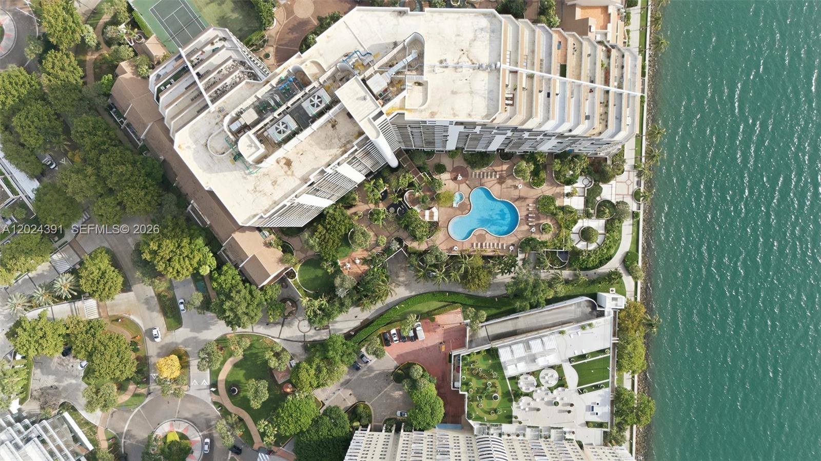 An aerial view shows a large apartment complex with a pool, landscaping, and waterfront access — 520 Brickell Key Dr # A1615, Miami FL 33131, MIAMI, FL