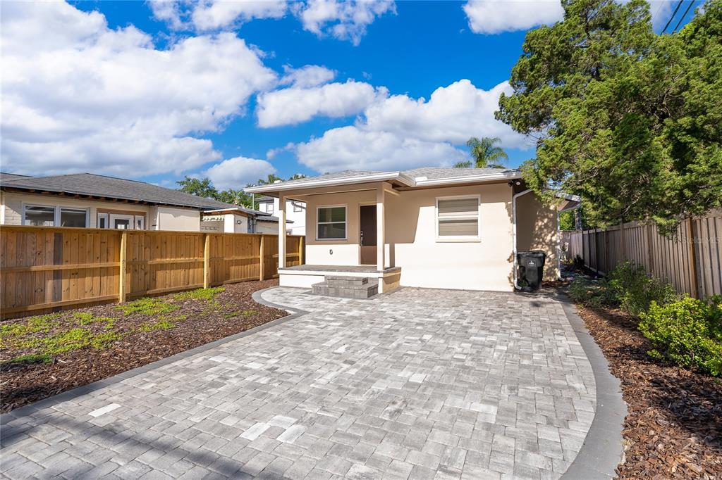 An open-concept living area features dark wood-look tile flooring and a kitchen with dark cabinetry — 623 FLORIDA STREET, ORLANDO, FL